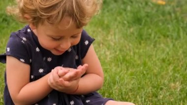 Bir çocuk bahçede uğur böceği tutuyor. Seçici odaklanma. Doğa.