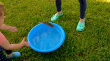 Bir çocuk kasedeki balıkla oynar. Seçici odaklanma. Çocuk.