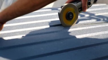 Bir adam öğütücüyle metal keser. Seçici odaklanma. insanlar.