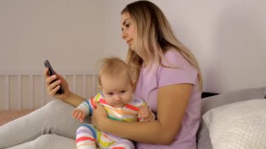 Telefonlu bir anne ve küçük bir bebek. Seçici odaklanma. çocuk.