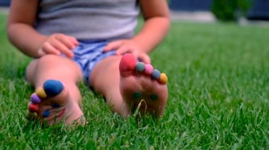 Childs 'ın ayakları çimlerin üzerine boyanmış. Seçici odaklanma. çocuk.