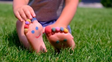 Childs 'ın ayakları çimlerin üzerine boyanmış. Seçici odaklanma. çocuk.