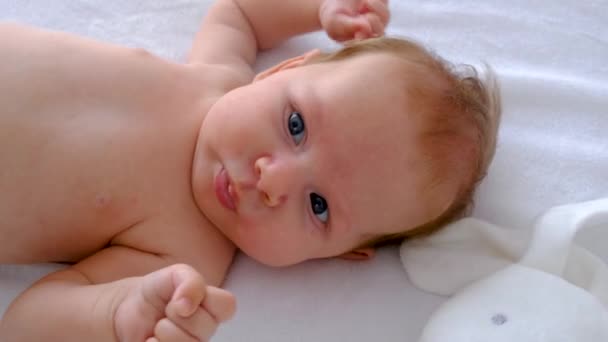 Μωρό Είναι Ξαπλωμένο Στο Κρεβάτι Και Παίζει Επιλεκτική Εστίαση Άνθρωποι — Αρχείο Βίντεο