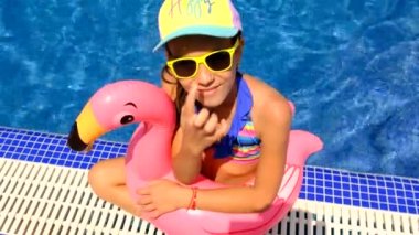 Bir çocuk havuzda flamingo çemberinde yüzüyor. Seçici odaklanma. çocuk.
