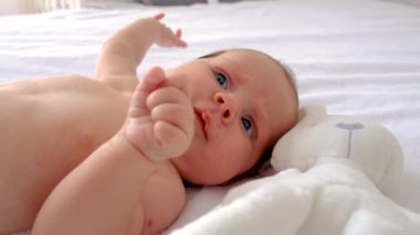 Bebek yatakta uzanıyor ve oynuyor. Seçici odaklanma. insanlar.