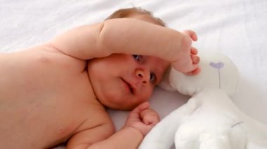 Bebek yatakta uzanıyor ve oynuyor. Seçici odaklanma. insanlar.