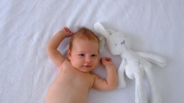 Bebek yatakta uzanıyor ve oynuyor. Seçici odaklanma. insanlar.