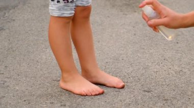 Anne çocuğa sivrisinek spreyi sıkar. Seçici odaklanma. çocuk.