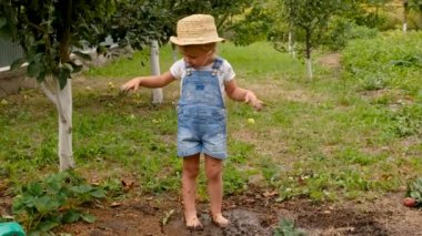 Bir çocuk bahçeye toprak atıyor. Seçici odaklanma. çocuk.