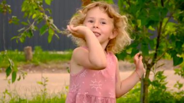 Bir çocuk bahçede bir salyangozla oynuyor. Seçici odaklanma. Doğa.