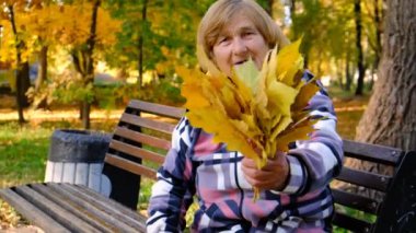 Sonbahar parkındaki yaşlı kadın. Seçici odaklanma. Doğa.