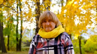 Sonbahar parkındaki yaşlı kadın. Seçici odaklanma. Doğa.