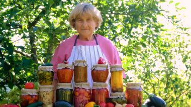 Bahçesinde konserve yiyecek ve sebze olan bir kadın. Seçici odak. .