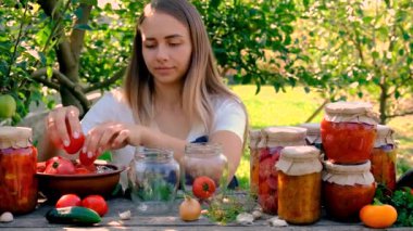 Bahçesinde konserve yiyecek ve sebze olan bir kadın. Seçici odaklanma. Doğa.