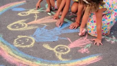 Çocuklar asfalta tebeşirle çizer. Seçmeli odaklanma. Çocuk.