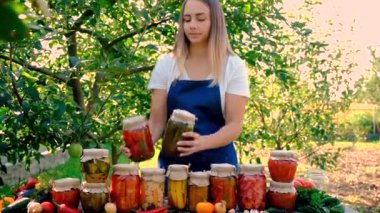 Bahçesinde konserve yiyecek ve sebze olan bir kadın. Seçici odaklanma. Doğa.