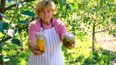 Bahçesinde konserve yiyecek ve sebze olan bir kadın. Seçici odak. .