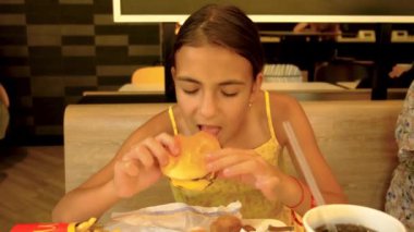 Çocuk kafede hamburger yiyor. Seçici odaklanma. Çocuk.