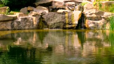 Şelaleli ve çeşmeli bir gölet. Seçici odaklanma. Doğa.