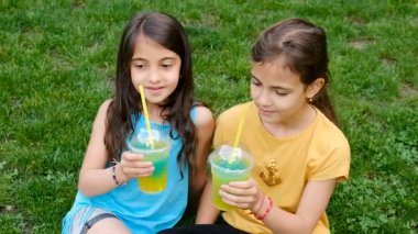 Çocuklar çimlerin üzerinde kokteyl içiyor. Seçici odaklanma. çocuk.