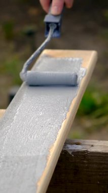 Bir adam bir tahtayı boyayla boyuyor. Seçici odaklanma. İnsanlar.