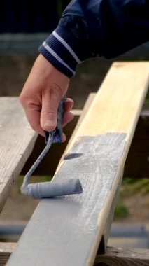 Bir adam bir tahtayı boyayla boyuyor. Seçici odaklanma. İnsanlar.