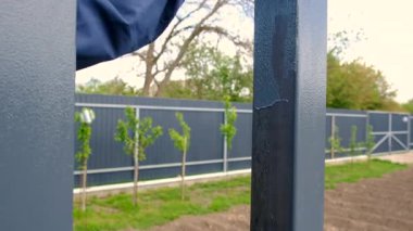 Metal direkleri boyayan adam. Seçici odaklanma. Doğa.