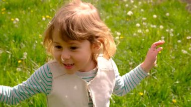 Çocuk parkta karahindiba üflüyor. Seçici odaklanma. Alerji çocuğu..