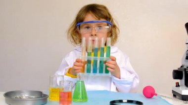 Test tüpleri, reaktörleri ve mikroskobu olan bir çocuğun laboratuvar incelemesi. Seçici odaklanma. çocuk.