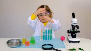Test tüpleri, reaktörleri ve mikroskobu olan bir çocuğun laboratuvar incelemesi. Seçici odaklanma. çocuk.