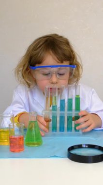 Test tüpleri, reaktörleri ve mikroskobu olan bir çocuğun laboratuvar incelemesi. Seçici odaklanma. çocuk.