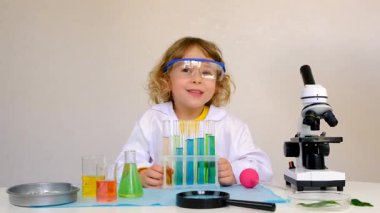 Test tüpleri, reaktörleri ve mikroskobu olan bir çocuğun laboratuvar incelemesi. Seçici odaklanma. çocuk.