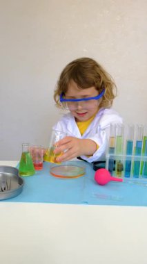 Test tüpleri, reaktörleri ve mikroskobu olan bir çocuğun laboratuvar incelemesi. Seçici odaklanma. çocuk.