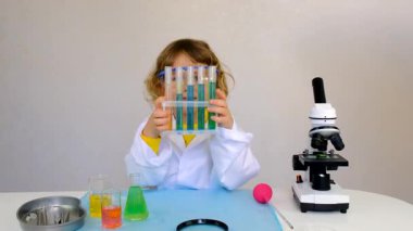 Test tüpleri, reaktörleri ve mikroskobu olan bir çocuğun laboratuvar incelemesi. Seçici odaklanma. çocuk.