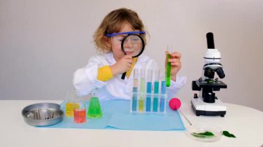 Test tüpleri, reaktörleri ve mikroskobu olan bir çocuğun laboratuvar incelemesi. Seçici odaklanma. çocuk.
