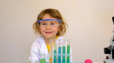 Test tüpleri, reaktörleri ve mikroskobu olan bir çocuğun laboratuvar incelemesi. Seçici odaklanma. çocuk.