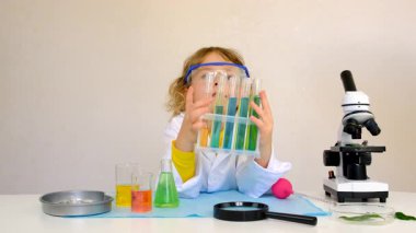 Test tüpleri, reaktörleri ve mikroskobu olan bir çocuğun laboratuvar incelemesi. Seçici odaklanma. çocuk.