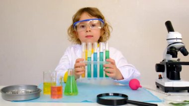 Test tüpleri, reaktörleri ve mikroskobu olan bir çocuğun laboratuvar incelemesi. Seçici odaklanma. çocuk.