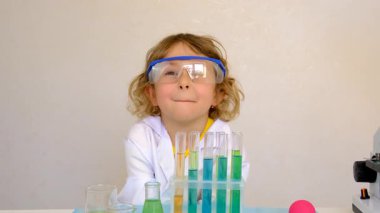 Test tüpleri, reaktörleri ve mikroskobu olan bir çocuğun laboratuvar incelemesi. Seçici odaklanma. çocuk.