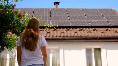 Adam evin çatısındaki güneş panellerine bakıyor. Seçici odaklanma. insanlar.