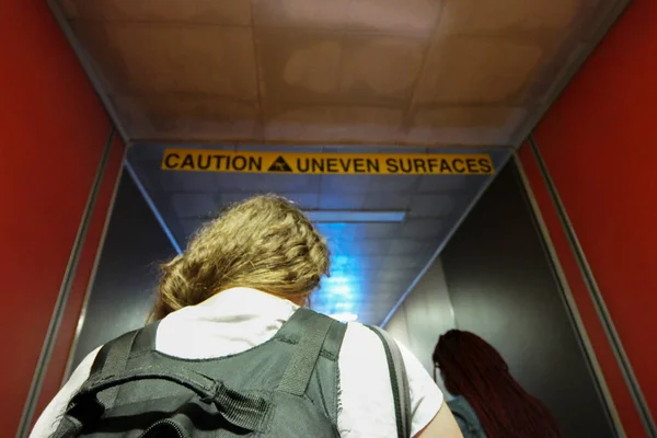 caution uneven surfaces back pack boarding a flight