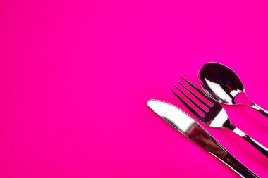 utensils fork spoon butter knife silver hot pink background