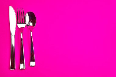 utensils fork spoon butter knife silver hot pink background