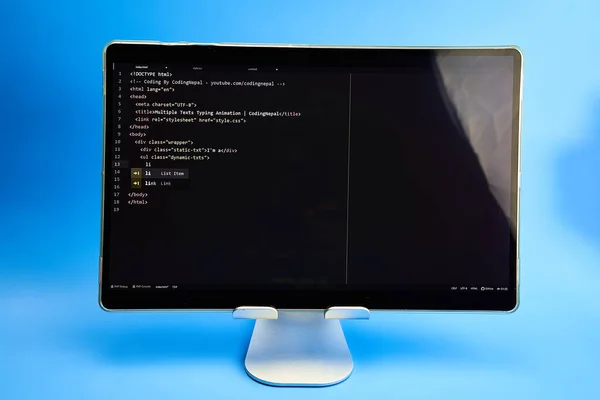 Writing computer code displayed on monitor light blue background