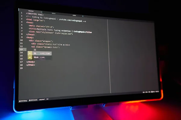 Writing computer code displayed on monitor neon blue and red lights