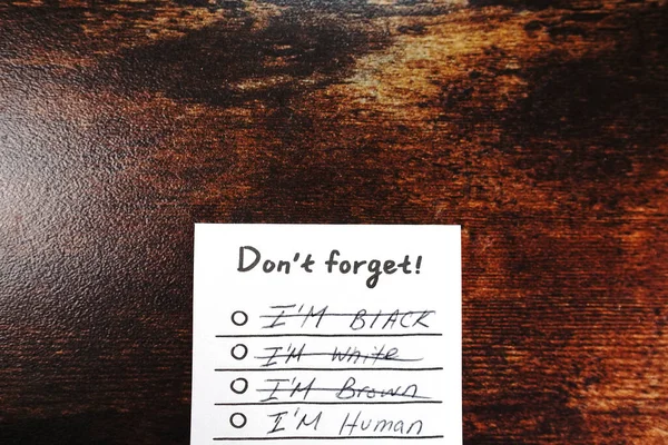 Message I\'m human don\'t forget on wood desk i\'m not black I\'m not white