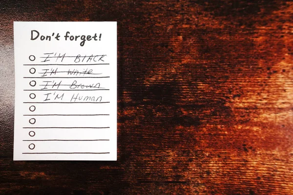 Message I\'m human don\'t forget on wood desk i\'m not black I\'m not white