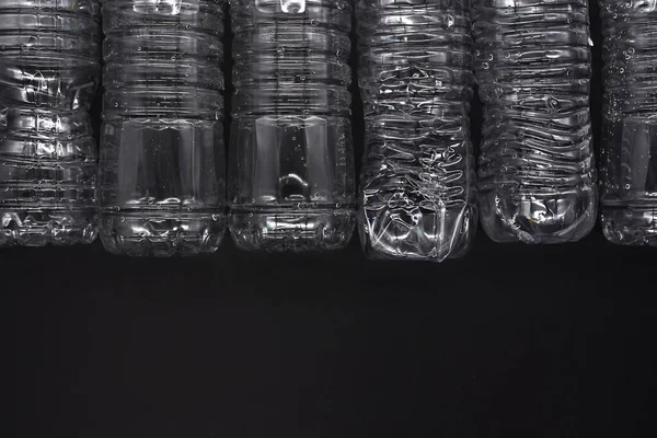 Empty plastic water bottles recycle material reduce waste black background