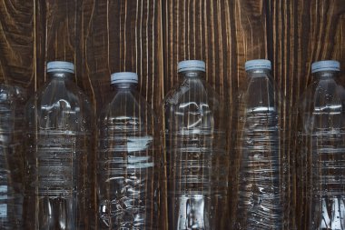 Empty plastic water bottles recycle material reduce waste wood background