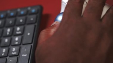 Parça topu klavyesinde çalışan siyah bir adam yazıyor.
